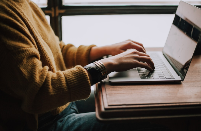 Professional reviewing a guide to RightAnswers vs Confluence on a laptop computer